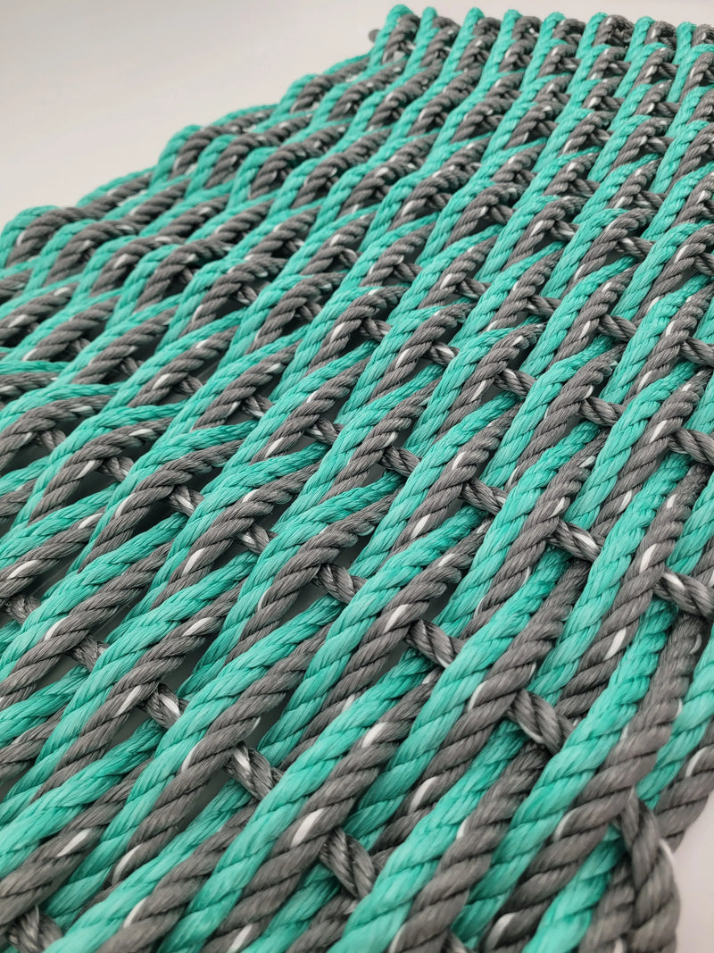image shows a gray and teal double weave rope mat