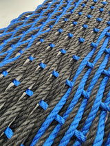 image shows a black and blue double weave rope mat, black stripe in the middle